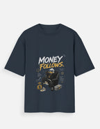 A navy blue short-sleeve t-shirt with a graphic print on the front. The graphic features the text 'MONEY FOLLOWS.