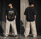 A split view of a man modeling an oversized black graphic T-shirt and loose beige drawstring pants in an outdoor urban setting. The shirt features a graphic with the text 'MONEY FOLLOWS' and a central illustration.