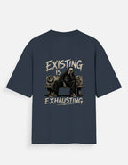 Blue oversized back print t-shirt featuring a tired man sitting on a couch with the quote "Existing Is Exhausting" in vintage grunge style by Kurowear.