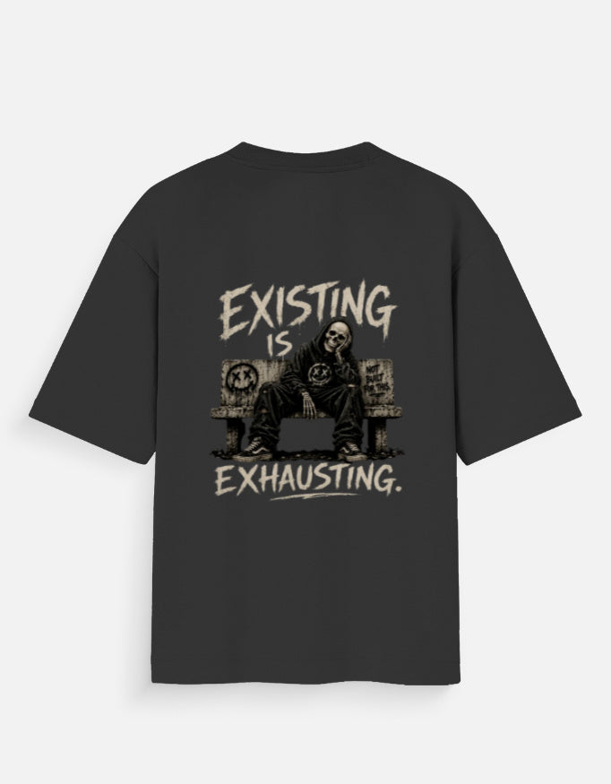 Black oversized back print t-shirt featuring a tired man sitting on a couch with the quote "Existing Is Exhausting" in vintage grunge style by Kurowear.