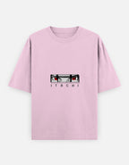 A light pink short-sleeve t-shirt featuring a graphic of the anime character Itachi Uchiha's eyes above the name 'ITACHI' printed in black capital letters, displayed on a light gray background.