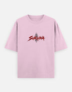 A light pink short-sleeve t-shirt with a red and black 'SUKUNA' graphic printed on the chest, displayed against a light gray background.