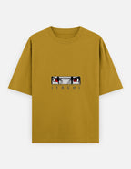 A mustard yellow short-sleeve t-shirt featuring a graphic of the anime character Itachi Uchiha's eyes and the name 'ITACHI' printed below, displayed on a light gray background.